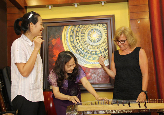 NSND Phương Bảo hướng dẫn du khách chơi đàn tranh khi đến với ngôi nhà nghệ sĩ của bà